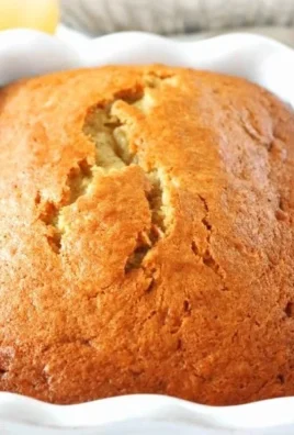 Moist banana bread made with sour cream, garnished with banana slices.