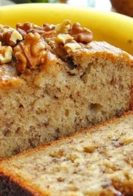 Freshly baked Banana Nut Bread with walnuts on a wooden cutting board