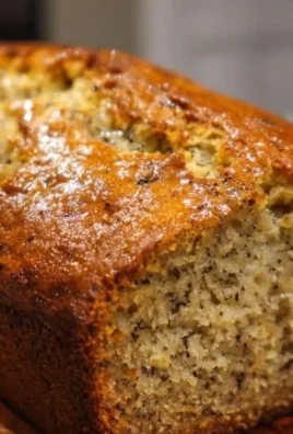 Slice of moist banana bread on a wooden table