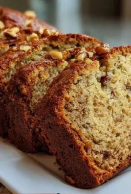 Loaf of simple moist banana nut bread with walnuts on a cutting board