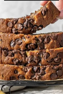 A slice of super moist chocolate chip banana bread topped with chocolate chips.