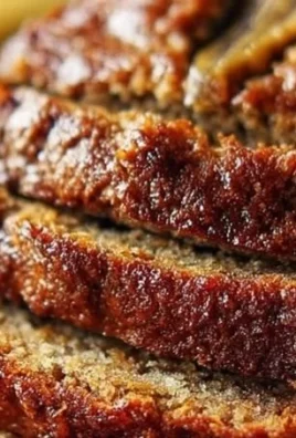 Loaf of ultimate moist banana bread on a wooden cutting board
