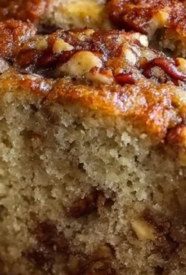 Sliced banana bread on a wooden board, showcasing its moist texture and rich color.