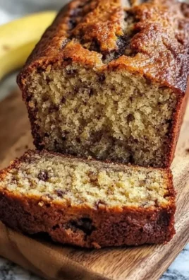Deliciously moist banana bread with nuts and chocolate chips on a wooden table
