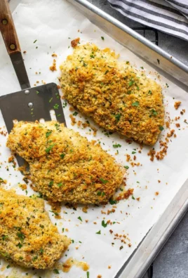 Baked Parmesan crusted chicken, golden brown and crispy, served with herbs.