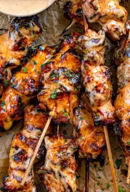 Delicious Bang Bang Chicken Skewers served on a platter with dipping sauce.