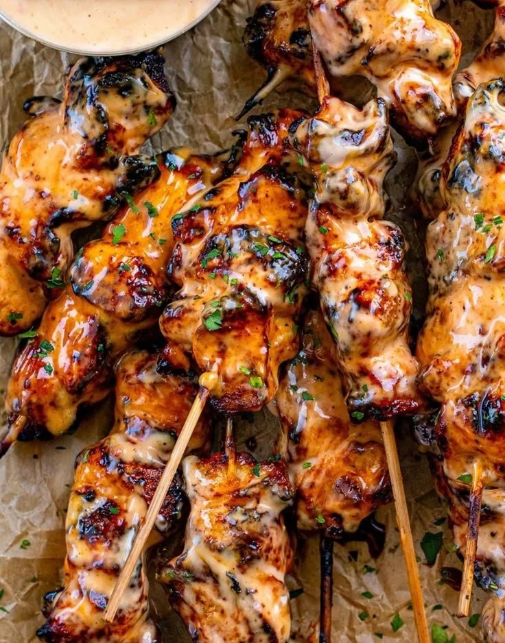 Delicious Bang Bang Chicken Skewers served on a platter with dipping sauce.