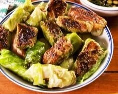 Homemade cabbage dumplings served on a plate with dipping sauce