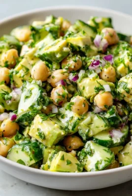 Chickpea avocado cucumber salad with lemon dressing in a bowl.