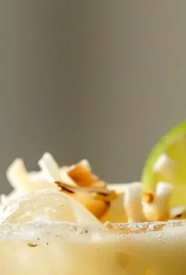 A refreshing Coconut Margarita cocktail served with a lime garnish and coconut rim.