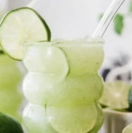 Delicious Crazy Limeade Slush in a glass with lime slices and ice