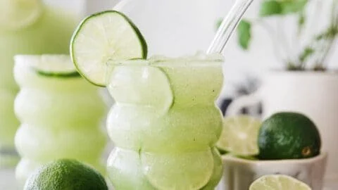 Delicious Crazy Limeade Slush in a glass with lime slices and ice