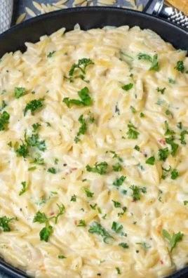Creamy garlic parmesan orzo served in a bowl with fresh herbs