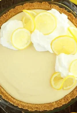 A slice of easy lemon cream pie with a golden crust and whipped cream topping.