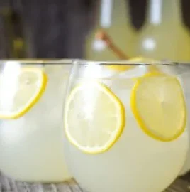 Refreshing glass of homemade fermented lemonade with lemon slices.