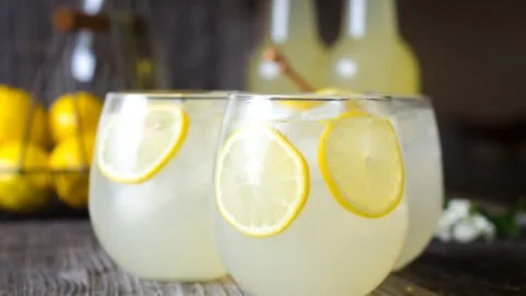 Refreshing glass of homemade fermented lemonade with lemon slices.