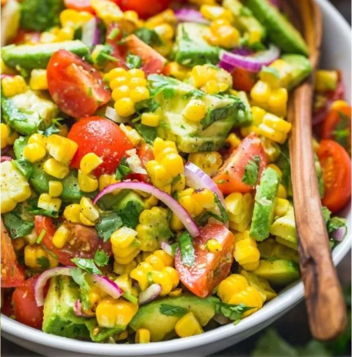 Delicious fresh corn salad with colorful vegetables and dressing