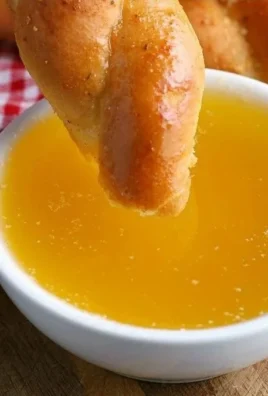 Delicious garlic butter dipping sauce in a small bowl with herbs and bread on the side.