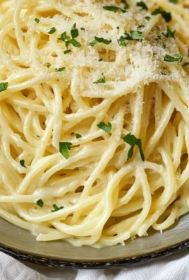 Delicious plate of Garlic Parmesan Pasta topped with herbs and grated cheese