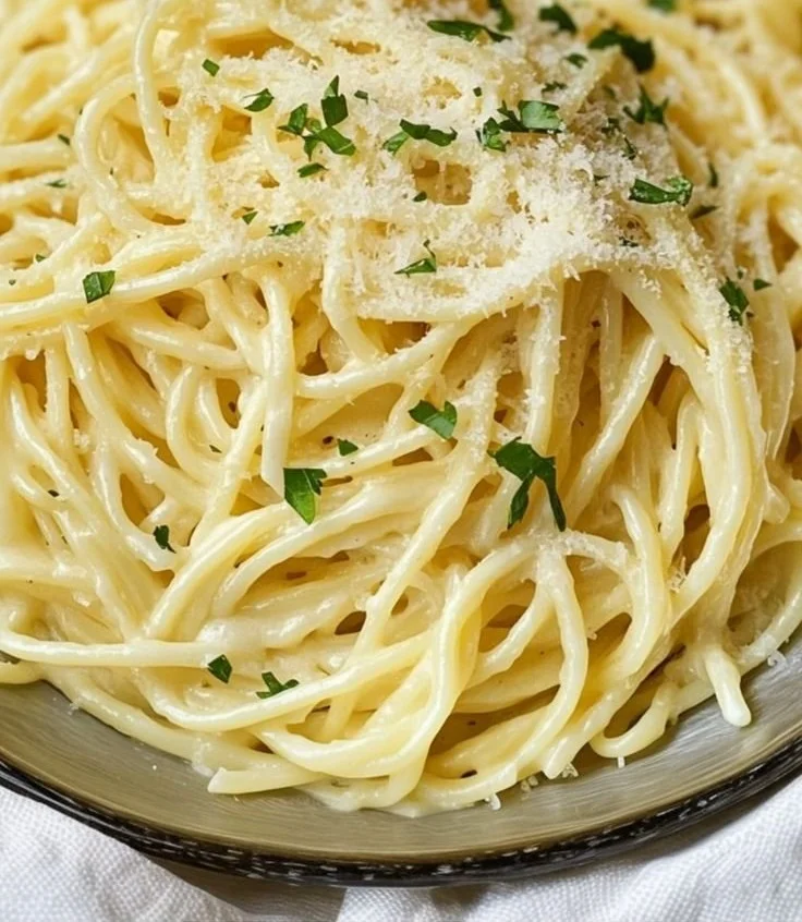 Delicious plate of Garlic Parmesan Pasta topped with herbs and grated cheese