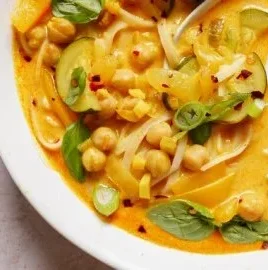 Bowl of gut-friendly Thai noodle soup with fresh herbs and spices