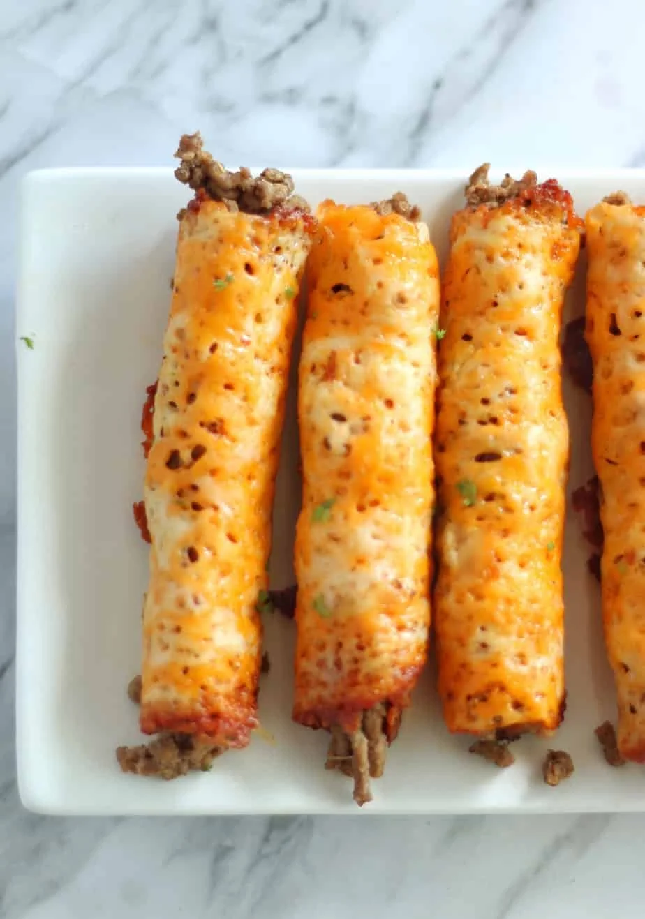 Delicious Keto Beef Taquitos served on a plate with toppings.