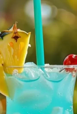 Vibrant mermaid lemonade in a glass with garnishes and a beautiful ocean backdrop.