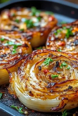 Oven roasted garlic cabbage steaks on a platter, garnished with herbs.