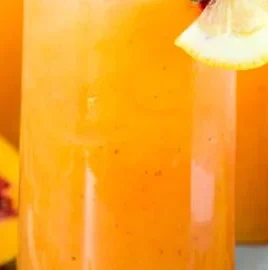 Glass of refreshing Peach Lemonade with peaches and lemons