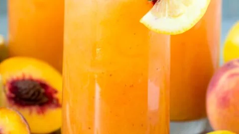Glass of refreshing Peach Lemonade with peaches and lemons
