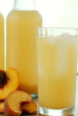 Refreshing Peaches and Cream Soda served in a glass with a peach garnish