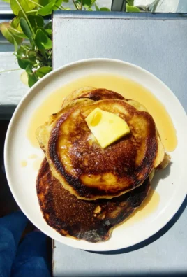 Plate of perfect crispy pancakes with syrup and berries