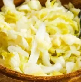 Delicious raw sauerkraut in a glass jar, showcasing its vibrant color and texture.