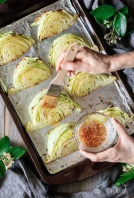 Plate of roasted cabbage wedges garnished with herbs and spices