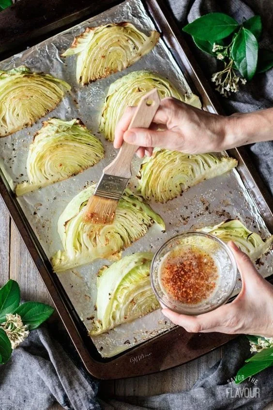 Plate of roasted cabbage wedges garnished with herbs and spices