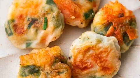 Shrimp and chive dumplings served on a plate, garnished with fresh herbs.