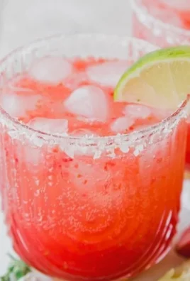Strawberry Lime Mocktail Margarita served in a glass with fresh strawberries and lime.