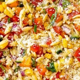 Colorful summer orzo pasta salad with fresh vegetables and herbs
