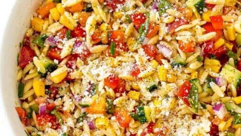 Colorful summer orzo pasta salad with fresh vegetables and herbs