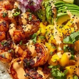 Delicious charred shrimp and avocado bowl garnished with fresh herbs.