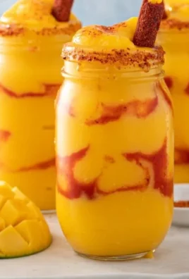 Bowl of authentic mangonada drink topped with fresh mango and chili powder