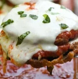 Baked Eggplant Parmesan topped with melted cheese and fresh basil