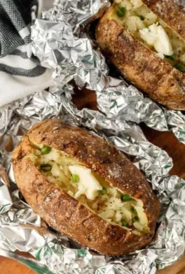 Grilled baked potatoes with seasonings on a barbecue grill