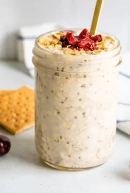 Bowl of Cherry Cheesecake Overnight Oats topped with fresh cherries and nuts.