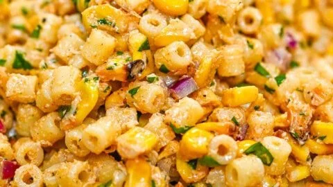 Colorful corn elote pasta salad with toppings and dressing