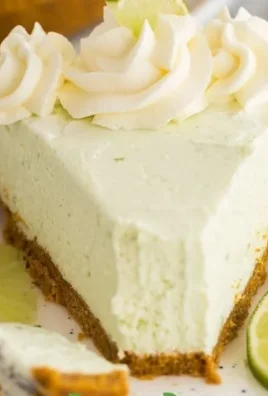 Slice of easy key lime cheesecake with fresh lime and graham cracker crust