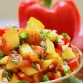 Bowl of easy Southern fresh peach salsa with colorful vegetables and peaches