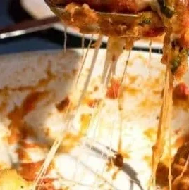 Delicious slice of homemade Eggplant Parmesan topped with melted cheese and herbs