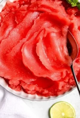 Bowl of homemade watermelon sorbet garnished with mint leaves