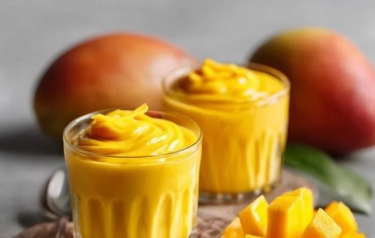 A plate of Mango Sticky Rice topped with fresh mango slices and coconut sauce